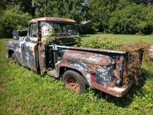 over grown old junk truck in the yard